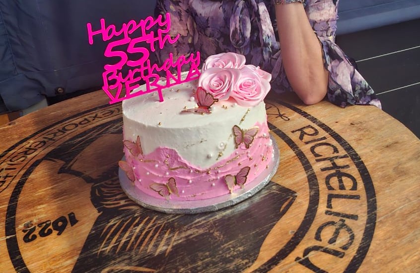 A birthday cake decorated with a personalized LNA cake topper showing a custom name and age